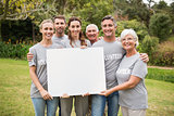 Happy volunteer family holding a blank