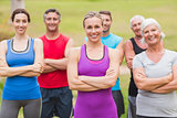 Happy athletic group smiling at camera with hands crossed