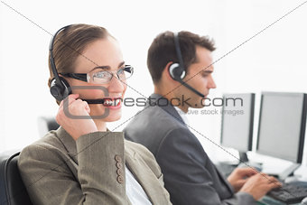 Business people with headsets using computers