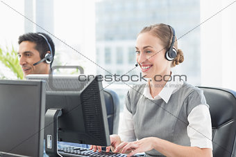 Business people with headsets using computers