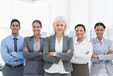 Business people with arms crossed smiling at camera