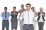 Happy business people looking at camera with thumbs up