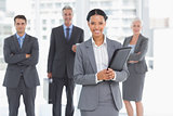 Businesswoman with colleagues behind in office