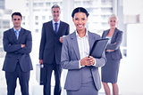 Businesswoman with colleagues behind in office