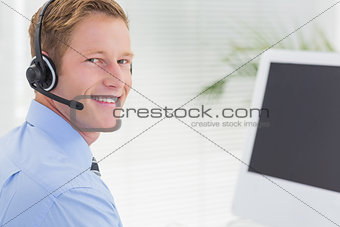 Handsome agent with headset typing on keyboard