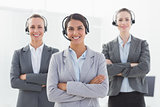 Business team wearing headsets and standing arms crossed