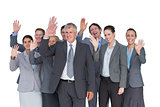 Smiling business team waving at camera