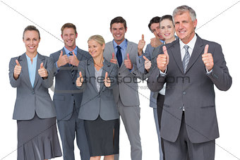 Smiling business team showing thumbs up
