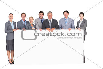 Smiling business team holding poster