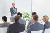 Pretty businesswoman talking in microphone during conference