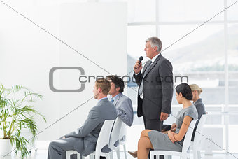 Businessman talking in microphone during conference
