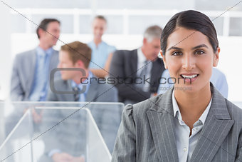 Smiling businesswoman looking at camera during conference