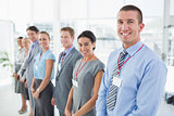 Business team standing in row and smiling at camera