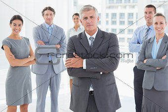 Smiling business team standing with arms crossed