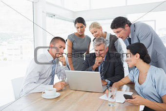 Concentrated business team working on laptop