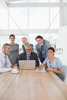 Smiling business team working together on laptop