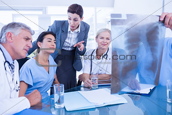 Team of doctors and businesswoman examining xray