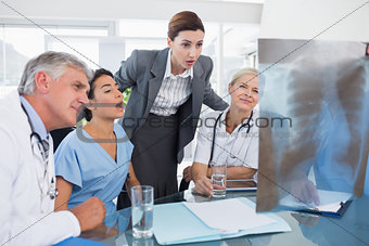 Team of doctors and businesswoman examining xray