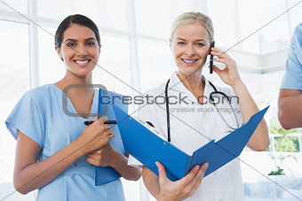 Doctor holding folder and having phone call