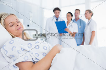 Sleeping patient with doctors behind