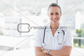 happy doctor smiling at camera with arms crossed