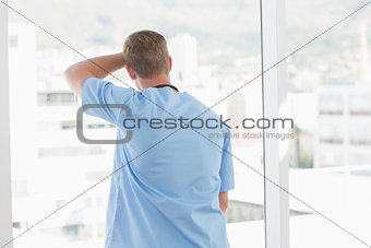 Male doctor looking through windows