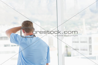 Male doctor looking through windows