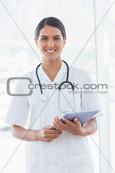 Happy doctor holding clipboard