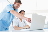 Doctors working with laptop computer