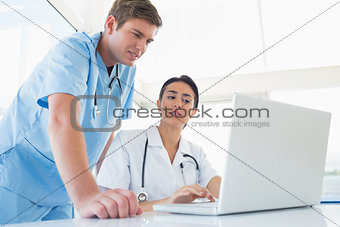 Doctors working on laptop computer