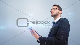 Composite image of businessman looking away while using tablet
