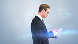Composite image of businessman in reading glasses using his tablet pc