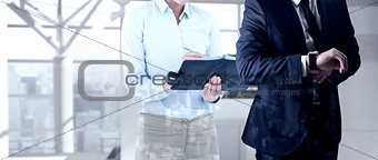 Composite image of handsome businessman checking the time