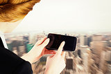 Composite image of businesswoman holding smartphone showing screen