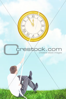 Composite image of businessman pulling a rope with effort