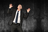 Composite image of businessman with hands up