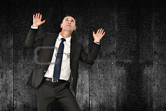 Composite image of businessman with hands up