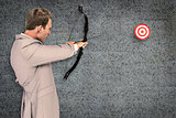 Composite image of businessman shooting target