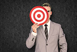 Composite image of businessman holding target
