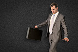 Composite image of businessman walking with his briefcase