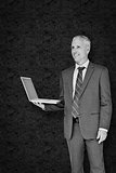 Composite image of businessman using laptop