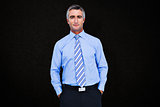Composite image of smiling businessman in suit with hands in pocket posing