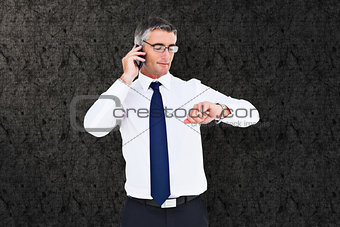 Composite image of businessman on the phone looking at his wrist watch