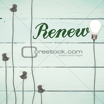 Renew against light bulbs on wooden background