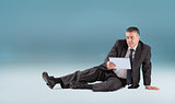 Composite image of mature businessman sitting using tablet