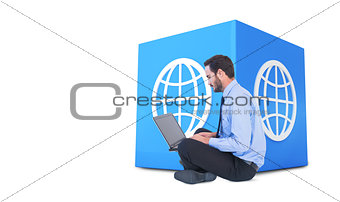 Composite image of businessman sitting on the floor using his laptop