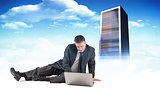Composite image of mature businessman sitting using laptop