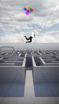 Composite image of businessman flying with balloons