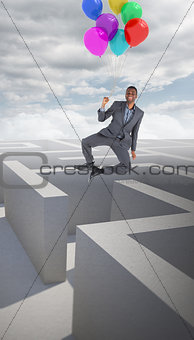 Composite image of businessman flying with balloons