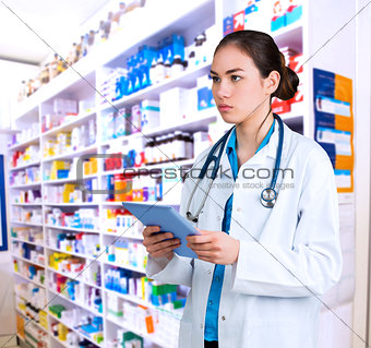 Composite image of young doctor standing with tablet pc